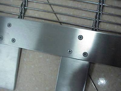 A corner of stainless steel woven wire drapery with hanging sheet.