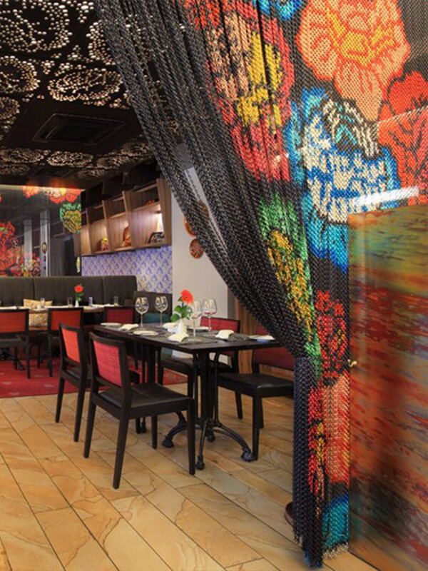 The restaurant uses a chain link curtain with patterns as the partition of the restaurant.