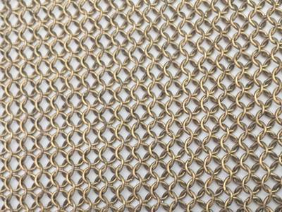 A piece of brass chainmail sheet is on the white background.