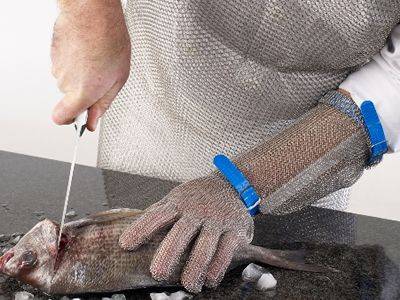 A chef is cutting fish chainmail armor and chainmail glove.