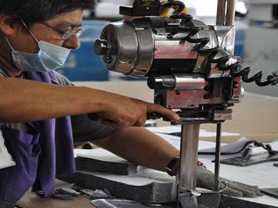 A person who is working in metal processing industry is wearing a chainmail glove on his left hand.