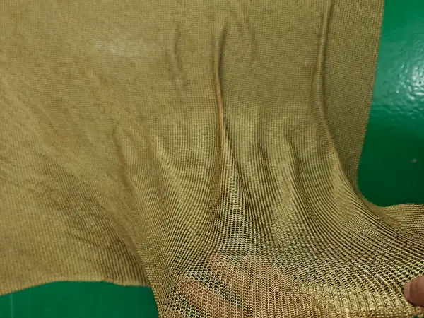 Worker displays gold chainmail curtain details