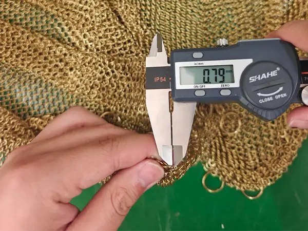 Measure the gold chainmail curtain wire diameter with a caliper.