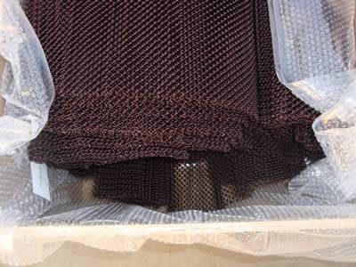 A bundle of copper mesh coil curtain is packaged into a roll by bubble plastic film.