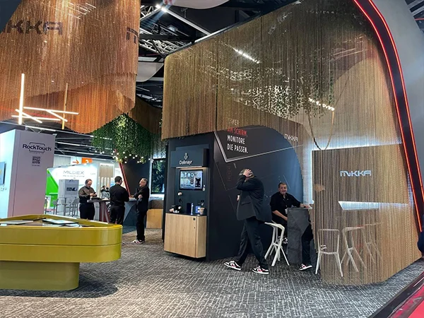The exhibition perimeter is adorned with a golden metal chain link curtain.