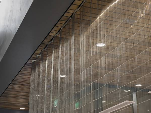 A piece of stainless steel wire mesh belts are used as movable curtain in the office building.