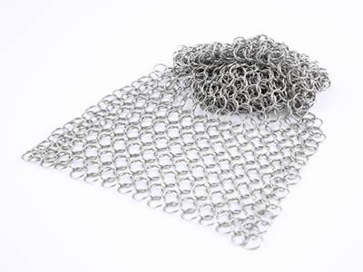 A piece of stainless steel chainmail baking with half folding.