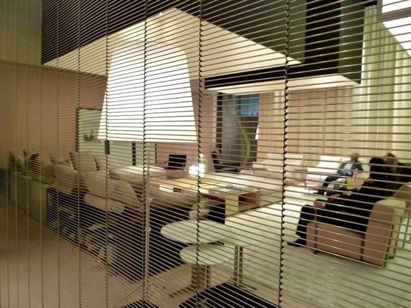 A piece of stainless steel wire mesh belt curtain is separating the reception area.