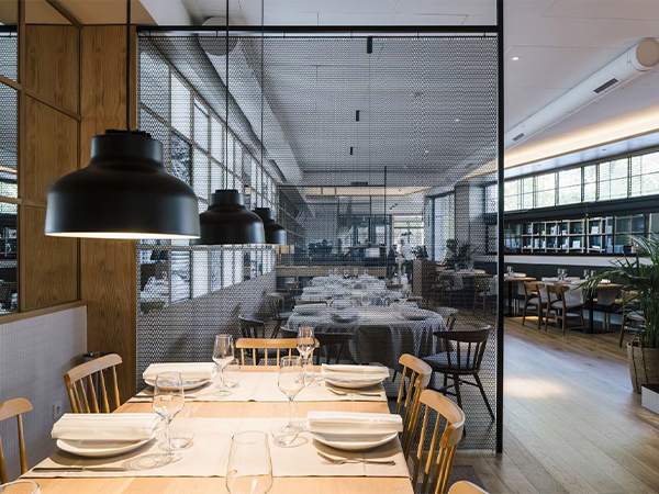 Stainless steel metallic curtain gama flexi divides the space in the dining room.