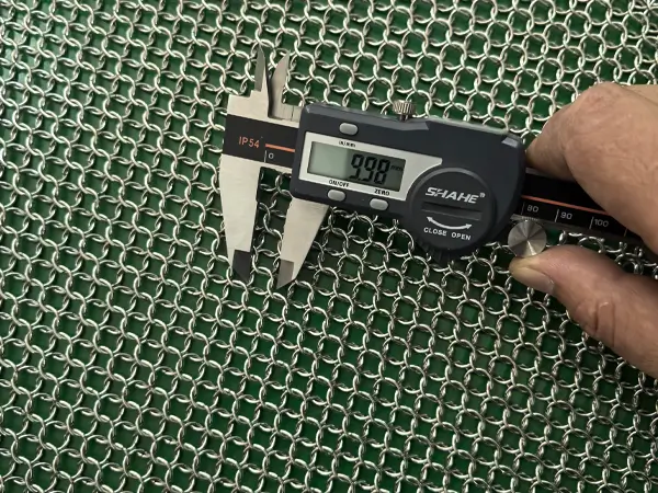 Measure the ring diameter of stainless steel welded chainmail curtain with a caliper.